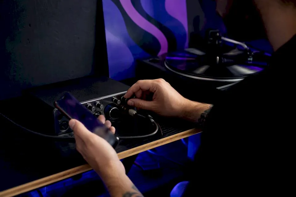 Hands adjusting mixer and holding phone with off-screen display