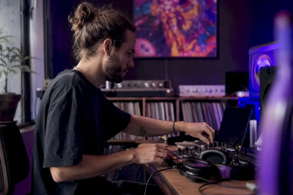 Hands adjusting audio mixer in home studio