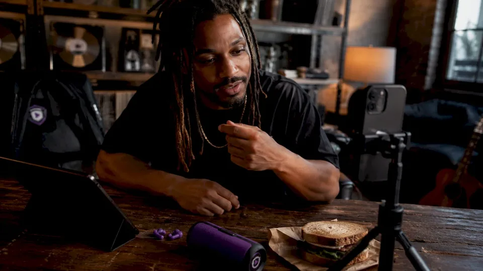 Musician filming short-form video outdoors at picnic table