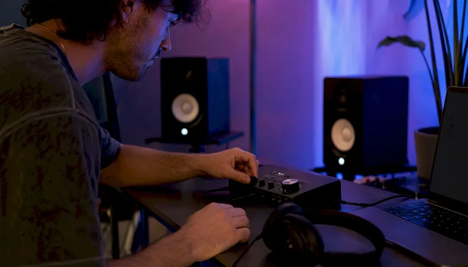 Indie musician's hands on desk with music gear