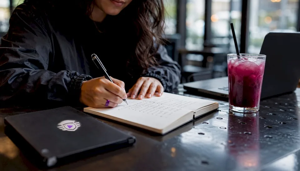 Hands writing playlist curation notes